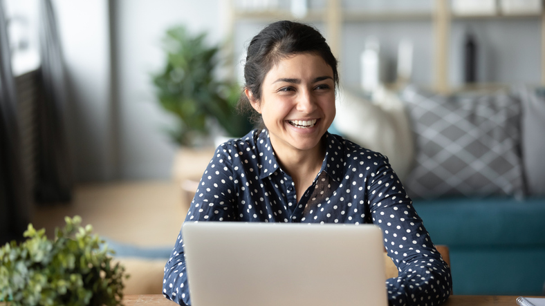 Smiling woman using laptop to make an online donation to a trustworthy charity.